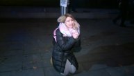 Žena na kolenima moli kordon policije