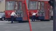 Čovek gura tramvaj na Novom Beogradu