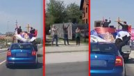 Sveštenici prošli ulicama Čačka na krovu automobila sa raširenim srpskim zastavama i svetim ikonama