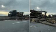 Debla poispadala po auto-putu: Prevrnula se prikolica teretnog kamiona koji je prevozio drva