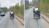 Veš mašinu prevoze preko mosta na triciklu: Tramvaj za njima mili
