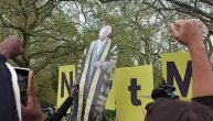 Okupljeni izviždali grupu demonstranata koja drži transparent "Nije moj kralj" na krunisanju Čarlsa