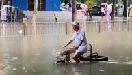 Poplave divljaju Pekingom ali to izgleda ne tangira ovog dekicu da provoza svoj tricikl