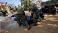 Izraelski vojnici iznose tela mrtvih civila iz kibuca Kfar Aza