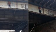 Dečko visi na Brankovom mostu i crta grafit